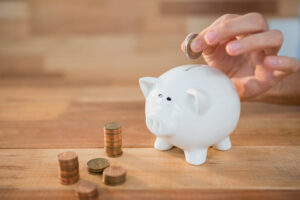 Close-up of hand inserting coin in piggy bank